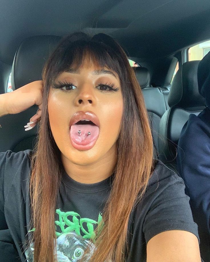 a woman sticking her tongue out in the back seat of a car