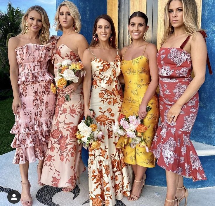 four women in dresses standing next to each other