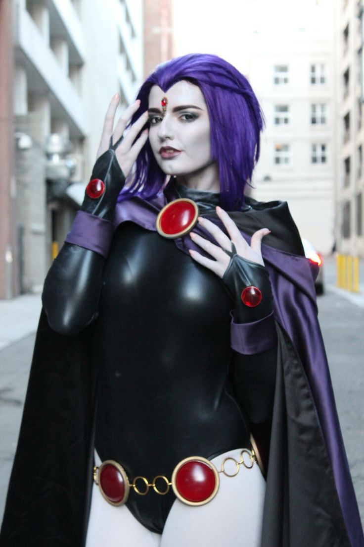 a woman dressed in black and purple is posing for the camera