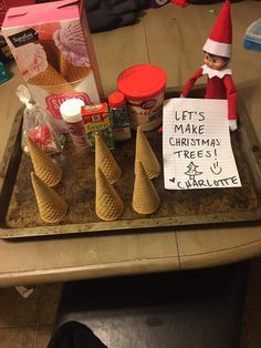 an elf is sitting at the table with some cones and ice creams on it