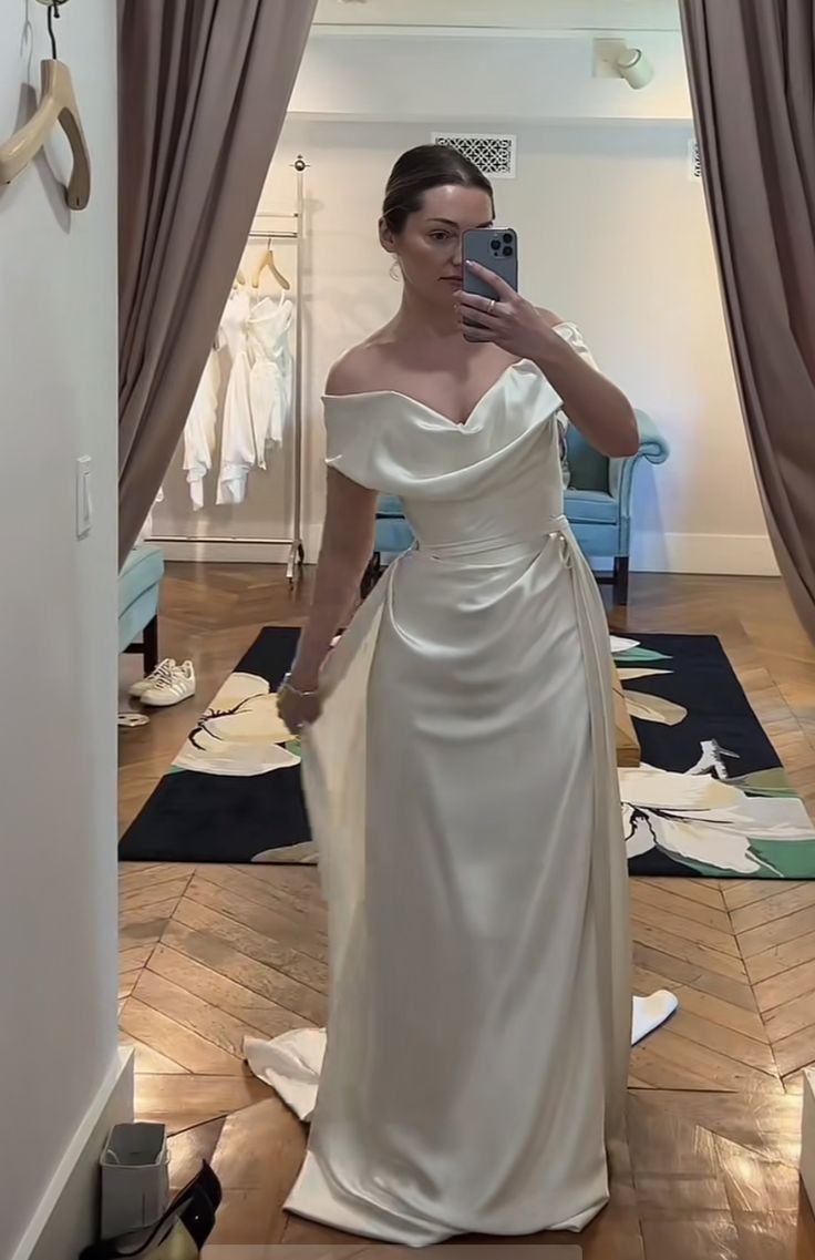 a woman in a white dress taking a selfie