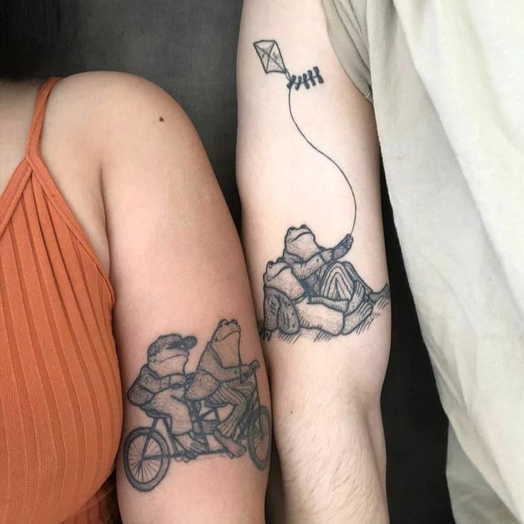 two people with tattoos on their arms and one has a kite attached to the arm