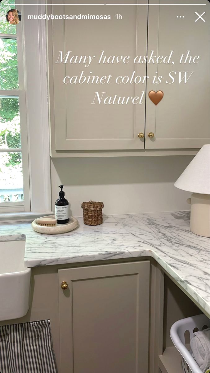 a kitchen with white cabinets and marble counter tops, along with a quote written on the wall