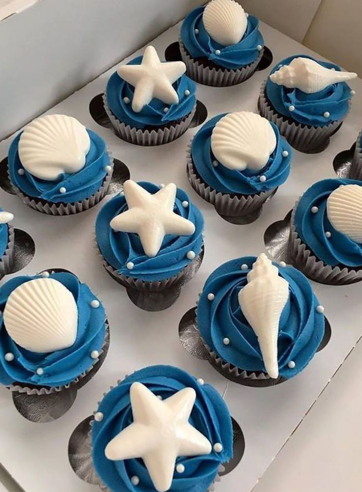 cupcakes decorated in blue and white with seashells