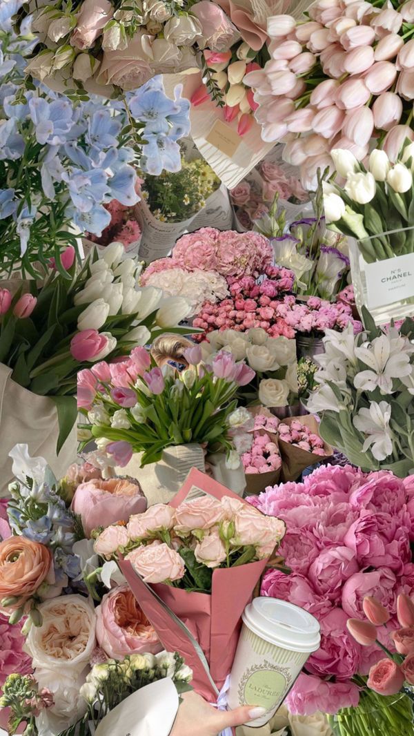 a bunch of flowers that are sitting on a table with some cups in front of them