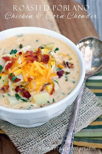 a white bowl filled with soup on top of a wooden table next to a spoon