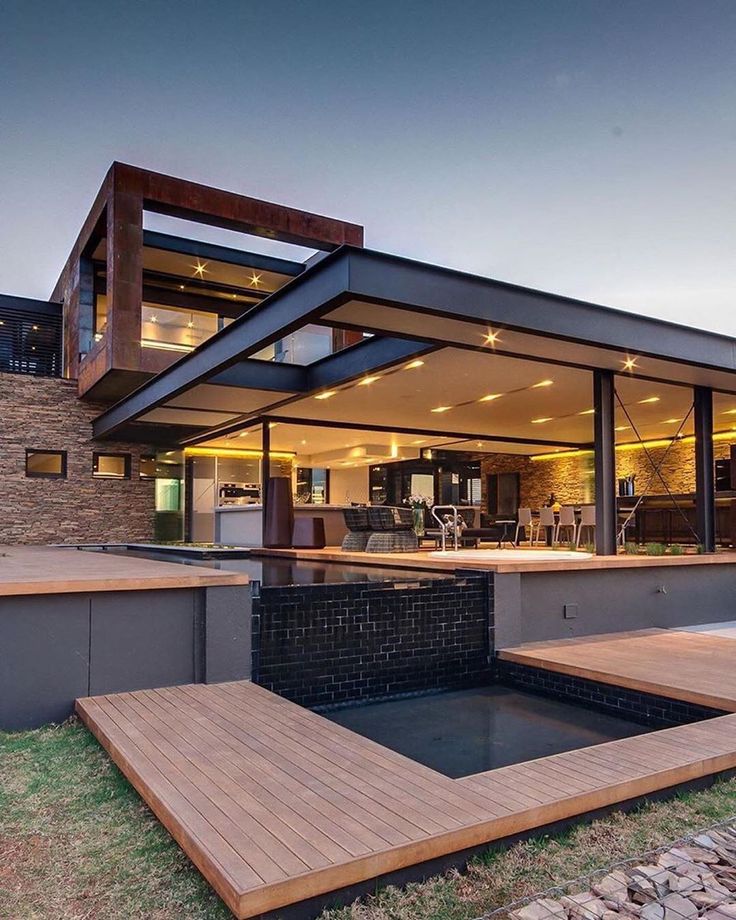 a modern house with wooden decking and glass windows