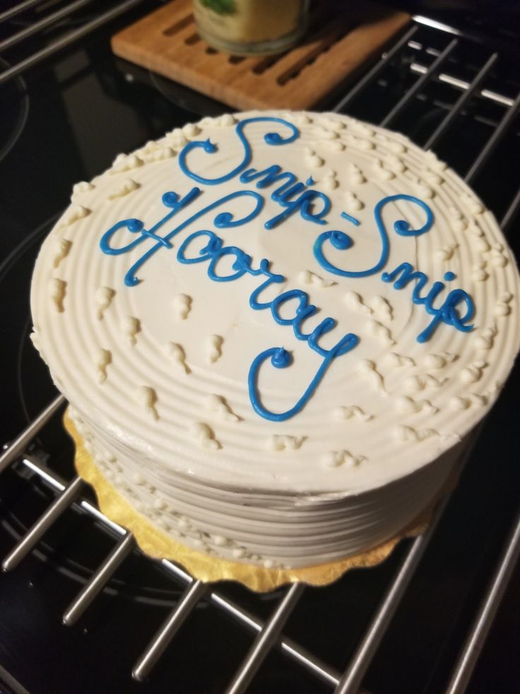 a white cake with blue writing on it sitting on top of a metal cooling rack