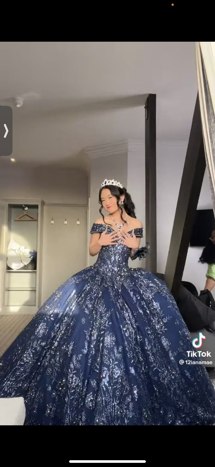 a woman in a blue dress is standing on the stairs with her arms around her neck