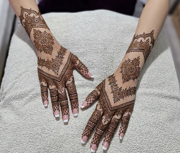 two hands with henna designs on them