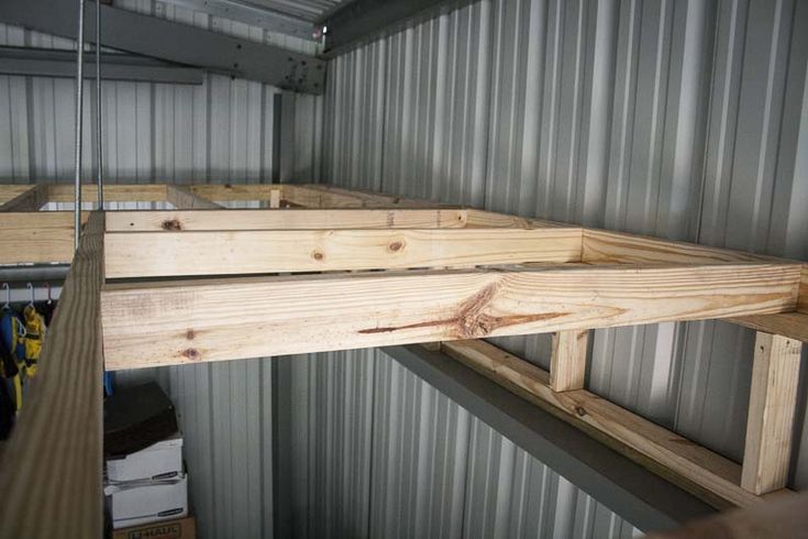 the inside of a storage room with metal walls and wood planks on the floor