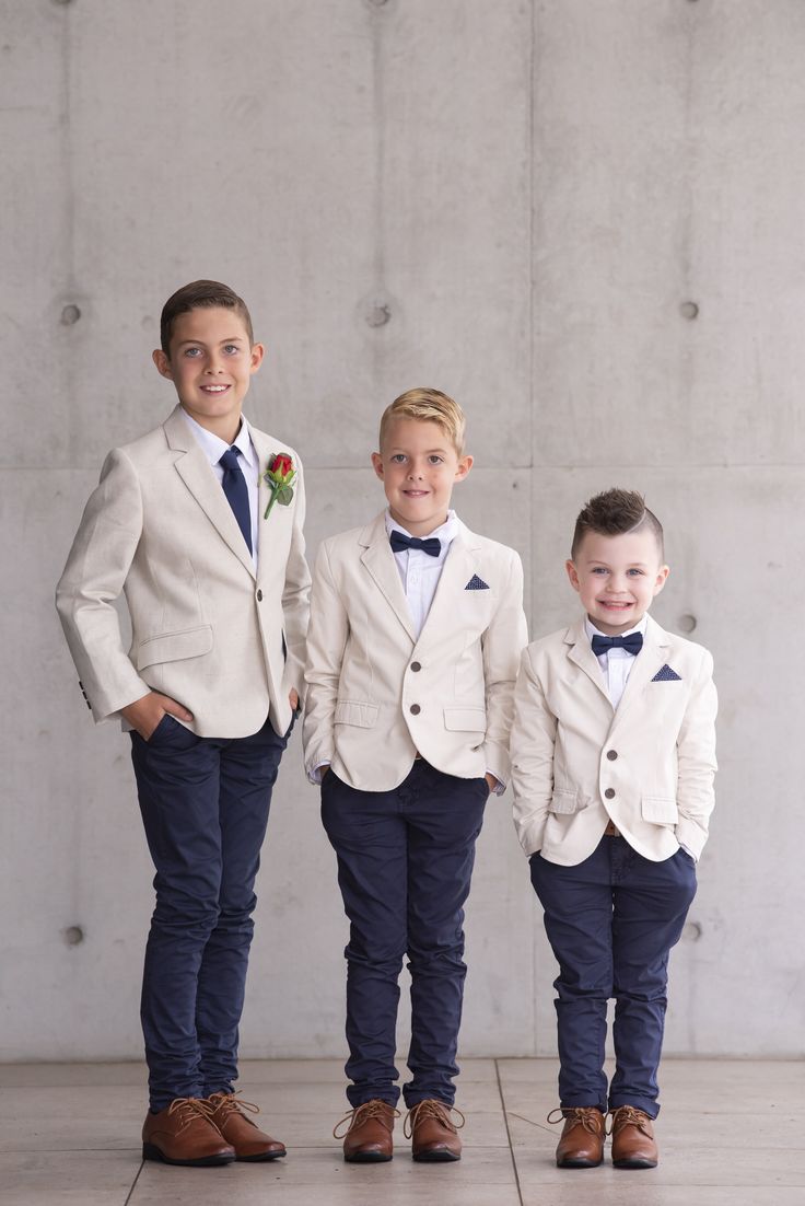 three young boys in suits and ties standing next to each other