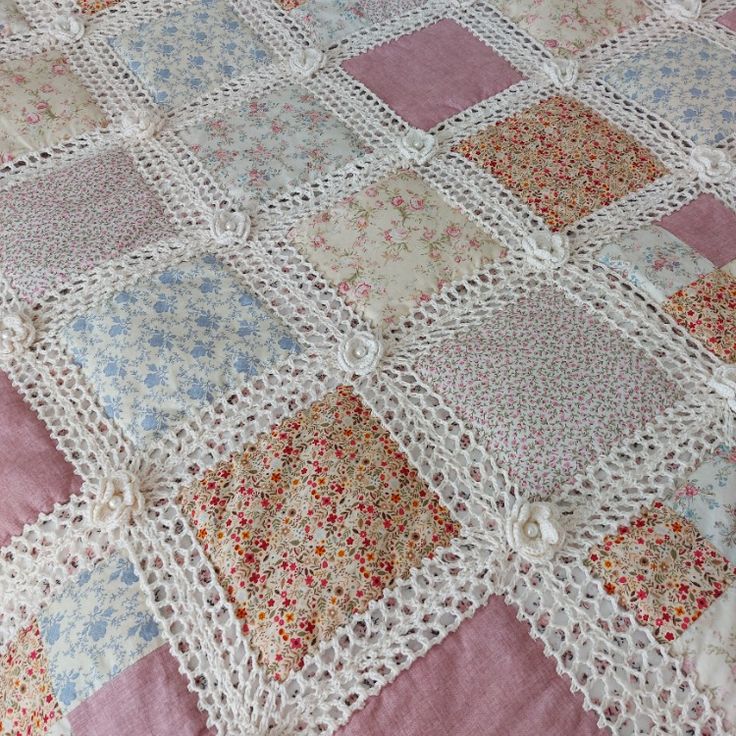 a crocheted blanket is laying on top of a pink and white bedspread