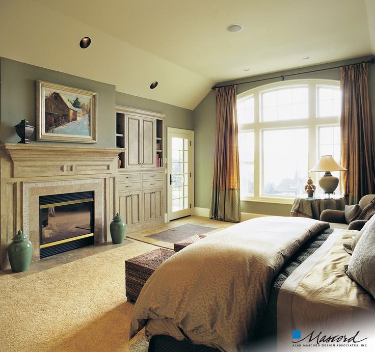 a large bedroom with a fireplace and bed in it