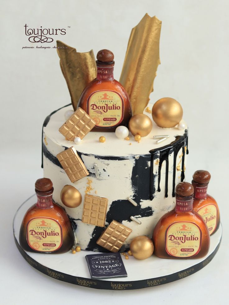 there is a cake decorated with liquor bottles and gold decorations