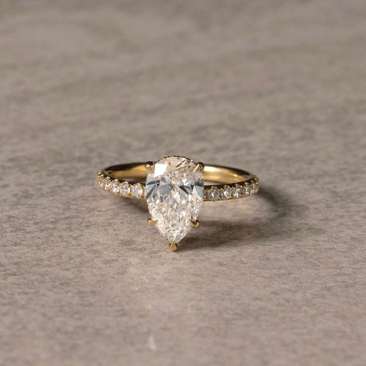 an engagement ring with a pear shaped diamond