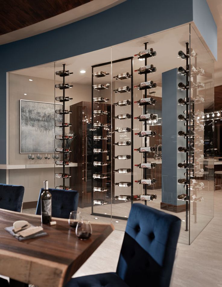 a dining room filled with blue chairs next to a wine rack