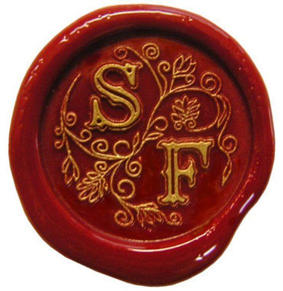 a red wax seal with the letter f in gold on it's side and an ornate design