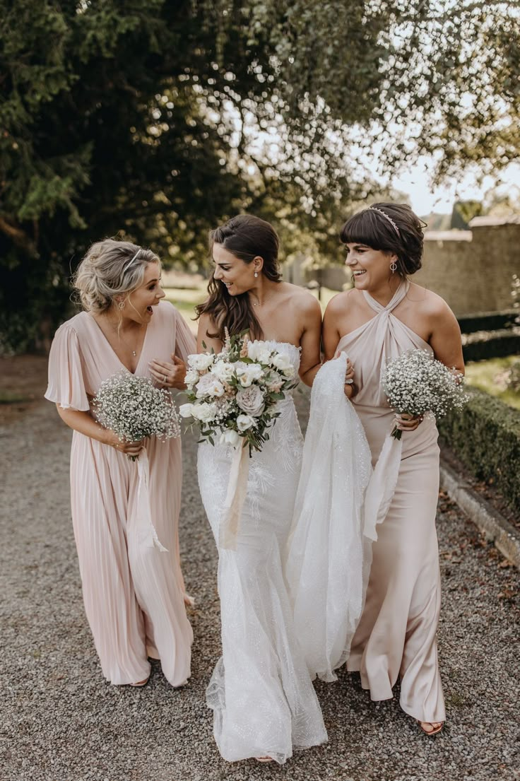 three bridesmaids are walking down the road together