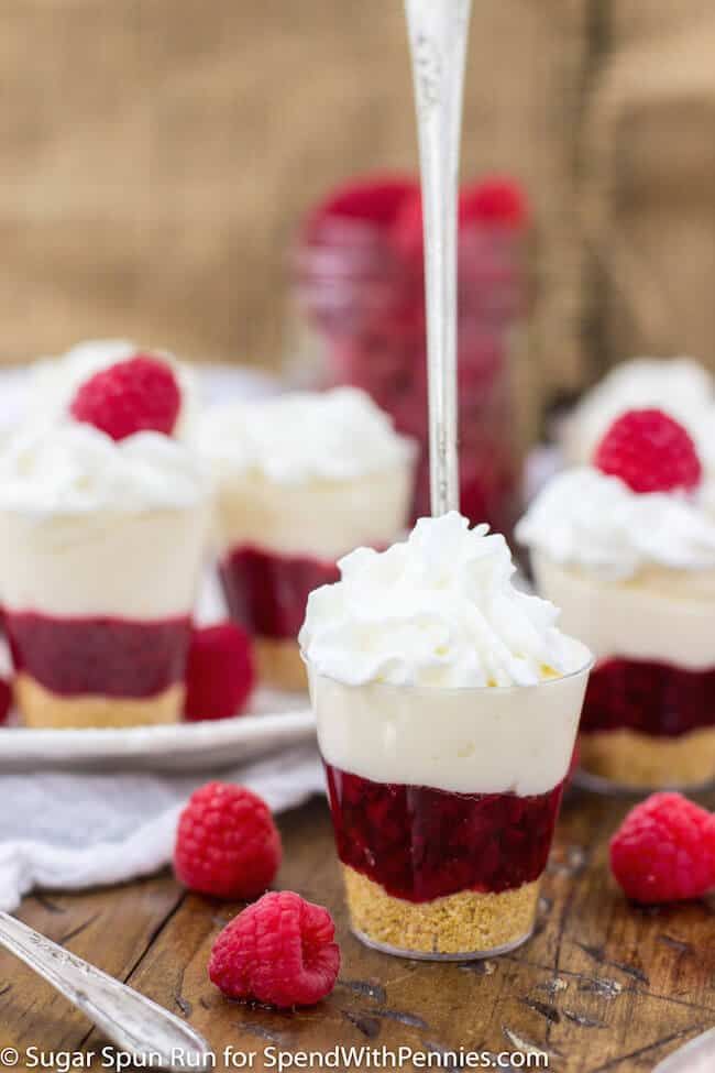 raspberry cheesecake cups with whipped cream and fresh raspberries