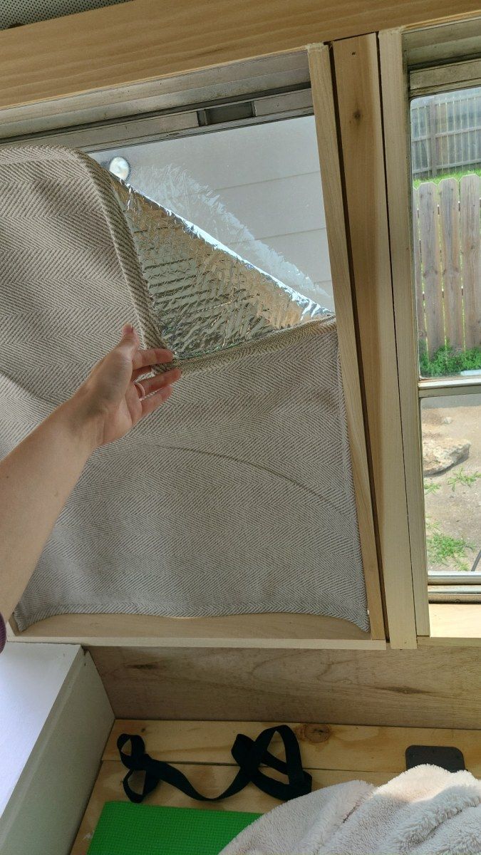 a person is holding something in their hand near a window that has been partially opened