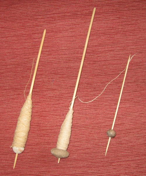 three different types of knitting needles on a red surface