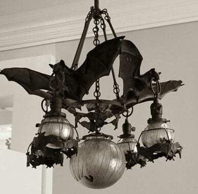 a black and white photo of a chandelier with bats hanging from the ceiling