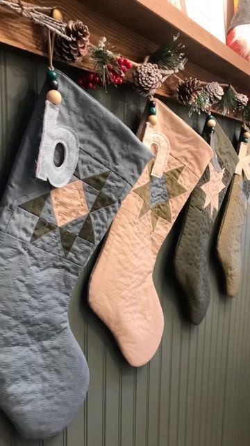 christmas stockings hanging on the wall with pine cones