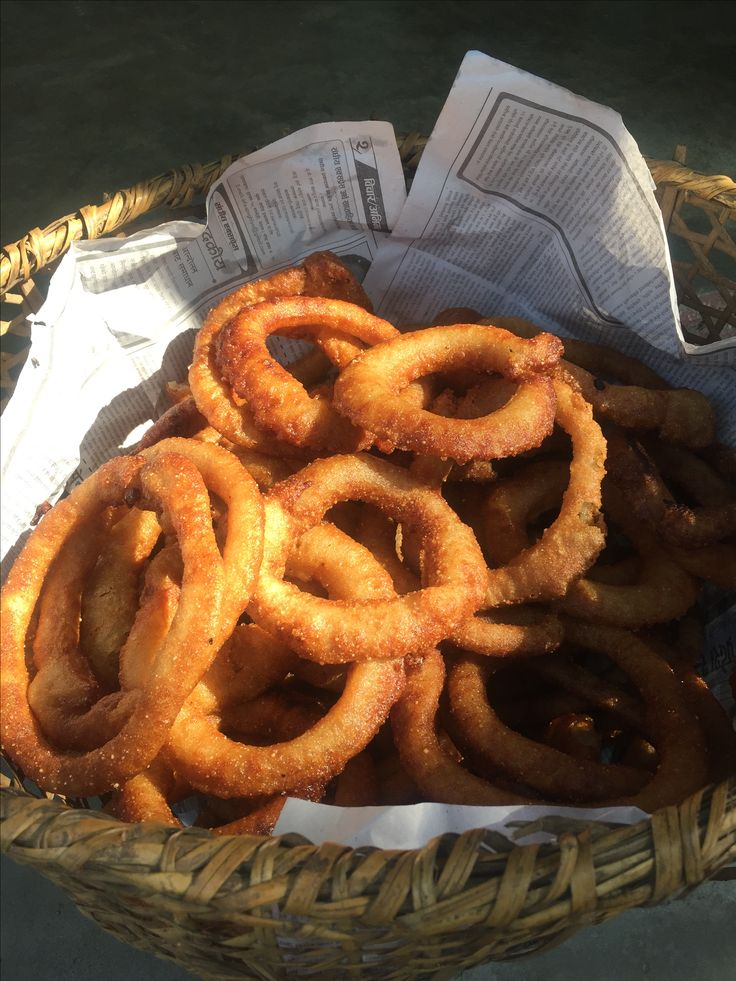 some onion rings are in a basket on the table