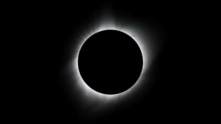 the moon is seen as it passes through the sun's corona during a solar eclipse