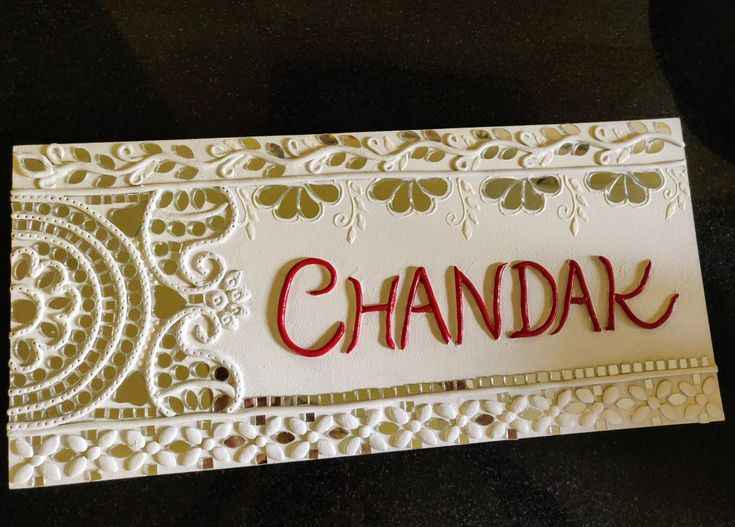 a close up of a card with the word chandak written on it in red