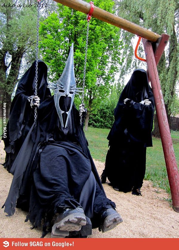 two people dressed in black and one wearing a mask with chains attached to their heads