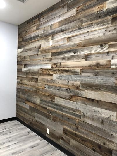 an empty room with wooden walls and flooring on the side, in front of a white wall