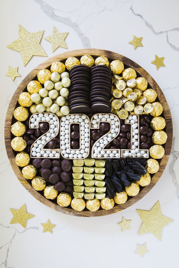 a wooden bowl filled with lots of chocolates and candy covered in the number twenty