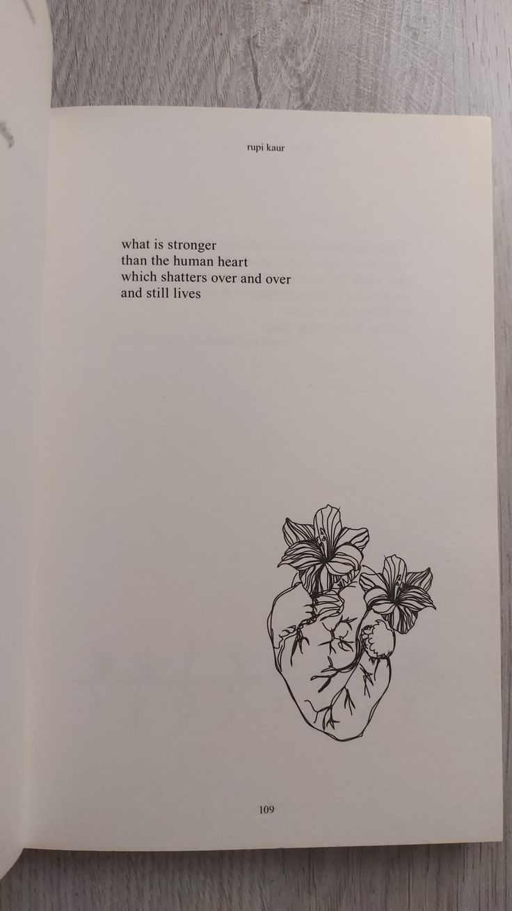 an open book with a drawing of a heart and flowers