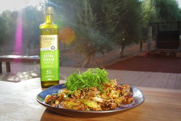 a plate of food on a table next to a bottle of wine and some trees