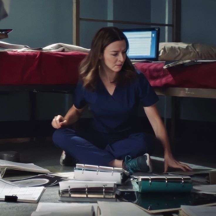 a woman sitting on the floor surrounded by papers