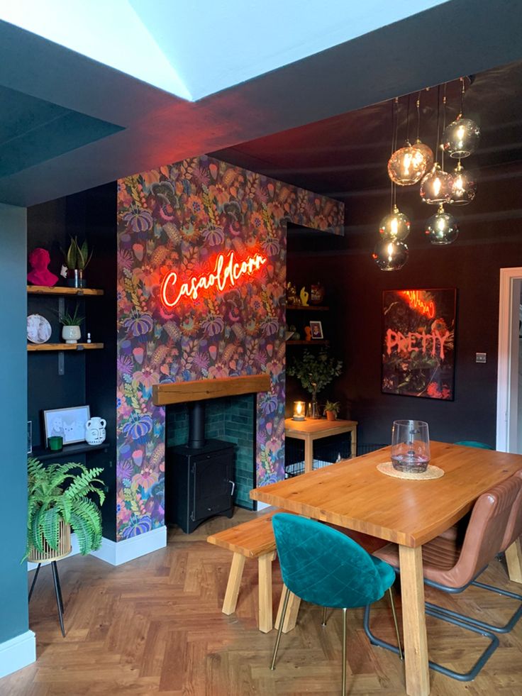 a dining room table with chairs and a fire place in front of a wall that has graffiti on it