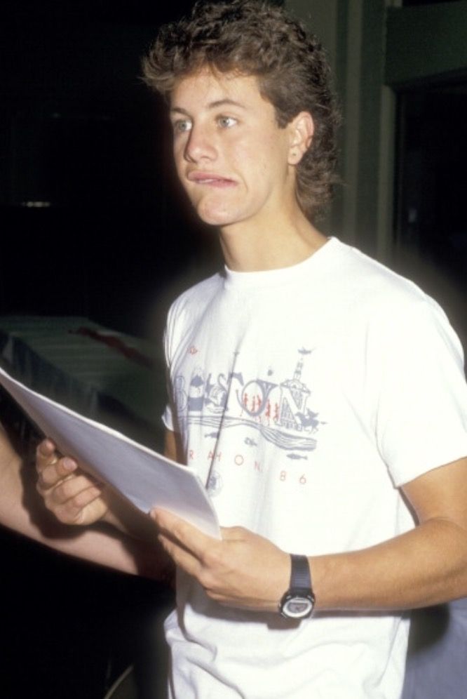 a young man holding a piece of paper in his hands