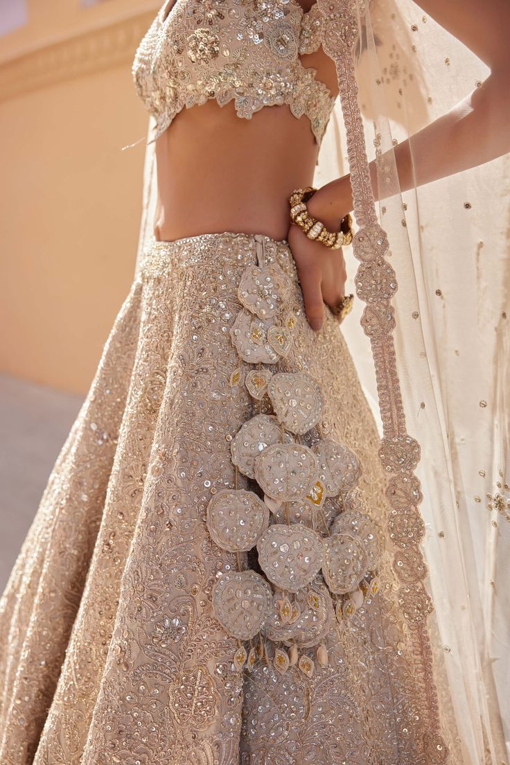 Step into timeless sophistication with our beige champagne embroidered lehenga, meticulously handcrafted with zardozi, french knots, aari work, and exquisite 3d floral embroidery. This stunning ensemble seamlessly blends traditional craftsmanship with modern elegance, perfect for weddings and special occasions. The soft beige champagne hue exudes understated luxury, while the intricate embroidery adds depth and charm to the lehenga. Ideal for those who appreciate meticulous detailing and timeles Luxury Traditional Lehenga For Eid, Luxury Lehenga For Eid Celebration, Luxury Elegant Lehenga For Eid, Luxury White Lehenga With Naqshi, Luxury Party Choli For Eid, Luxury Georgette Lehenga For Wedding, Luxury Self-design Lehenga For Party, Luxury Semi-stitched Lehenga For Wedding, Luxury Tissue Silk Lehenga With Dabka Detailing