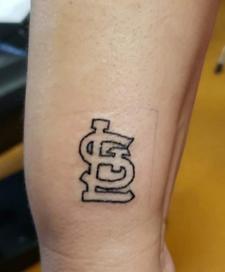 a person with a small tattoo on their arm that has the letter e in it