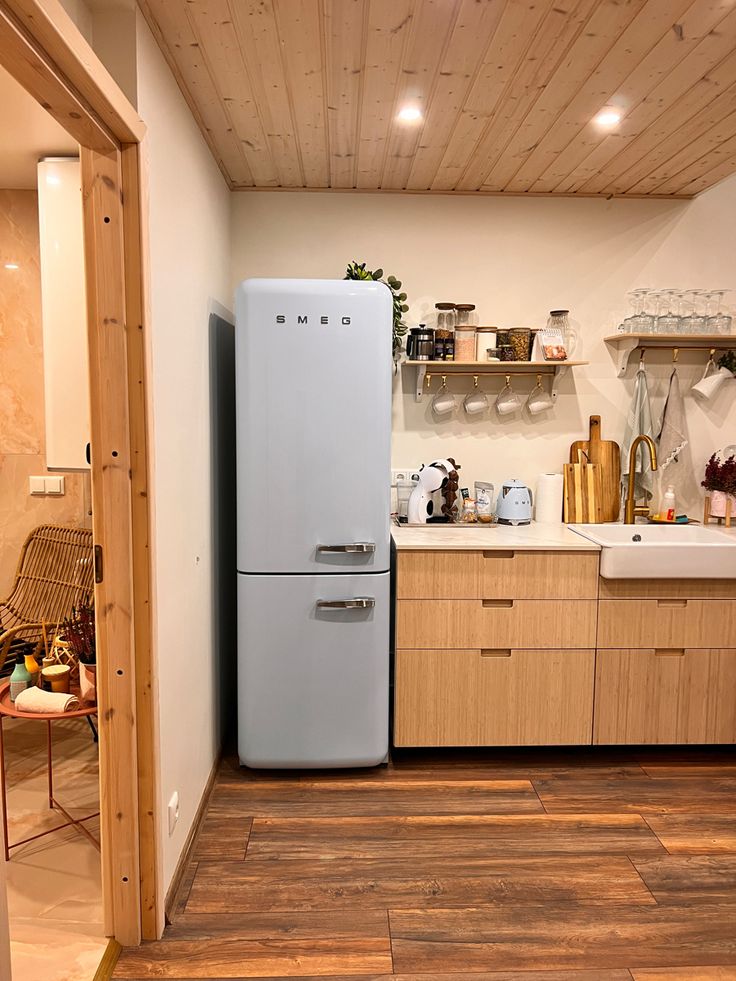 a white refrigerator freezer sitting inside of a kitchen next to a wooden counter top