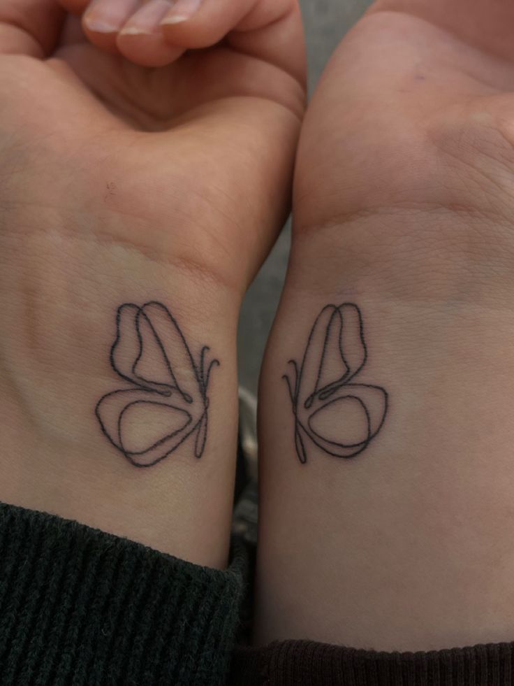 two people with matching tattoos on their wrist