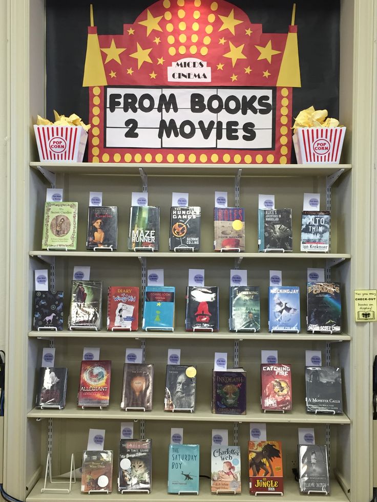 there is a book shelf that has movies on it and popcorn boxes in front of it