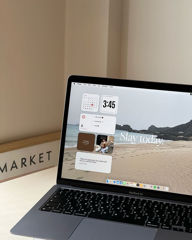 an open laptop computer sitting on top of a desk next to a sign that says stay today