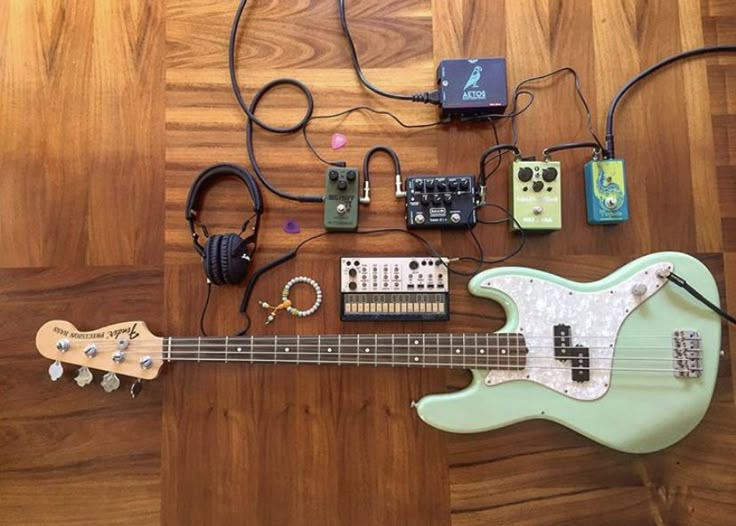 an electric guitar and other electronics on a wooden floor