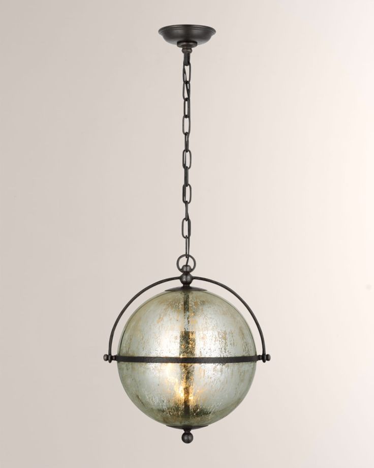 a glass ball hanging from a chain on a light fixture in an old - fashioned style