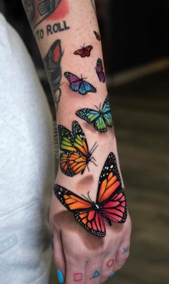 a woman's arm with colorful butterflies on it