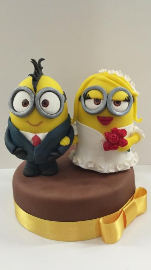 two yellow minion wedding cakes sitting on top of a table