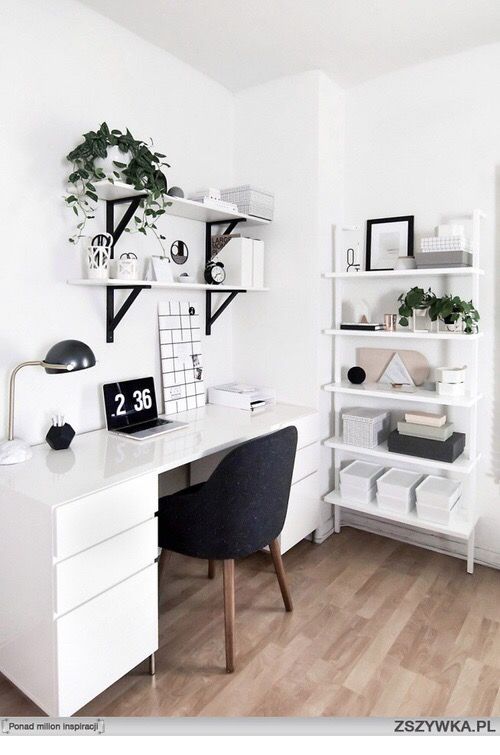 a white desk topped with a computer monitor next to a book shelf filled with books